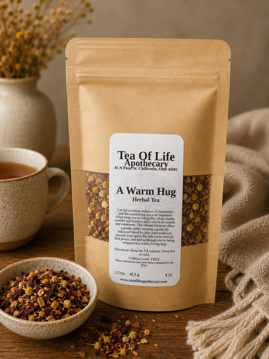 A Warm Hug Herbal Tea by Tea of Life Apothecary displayed in a cozy rustic setting with chamomile-rich loose herbal tea, ceramic mug, and soft natural textures to evoke warmth, relaxation, and comfort.