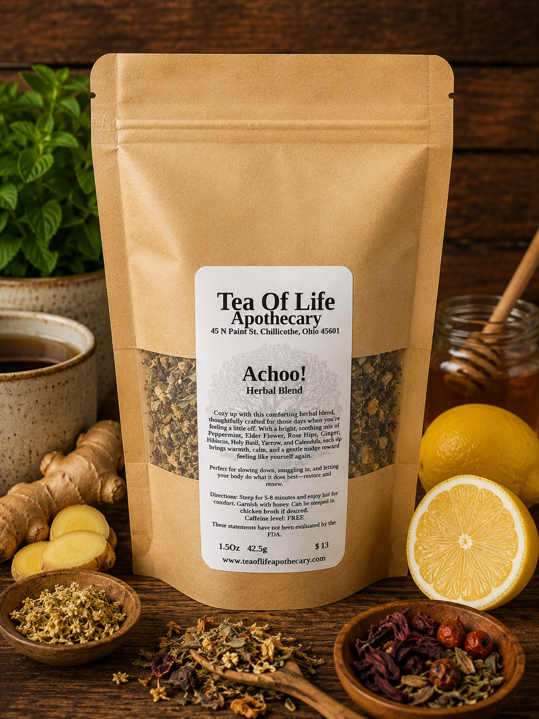 Achoo Herbal Blend by Tea of Life Apothecary displayed with ginger, lemon, honey, elderflower, and a warm cup of herbal tea in a cozy wellness setting.