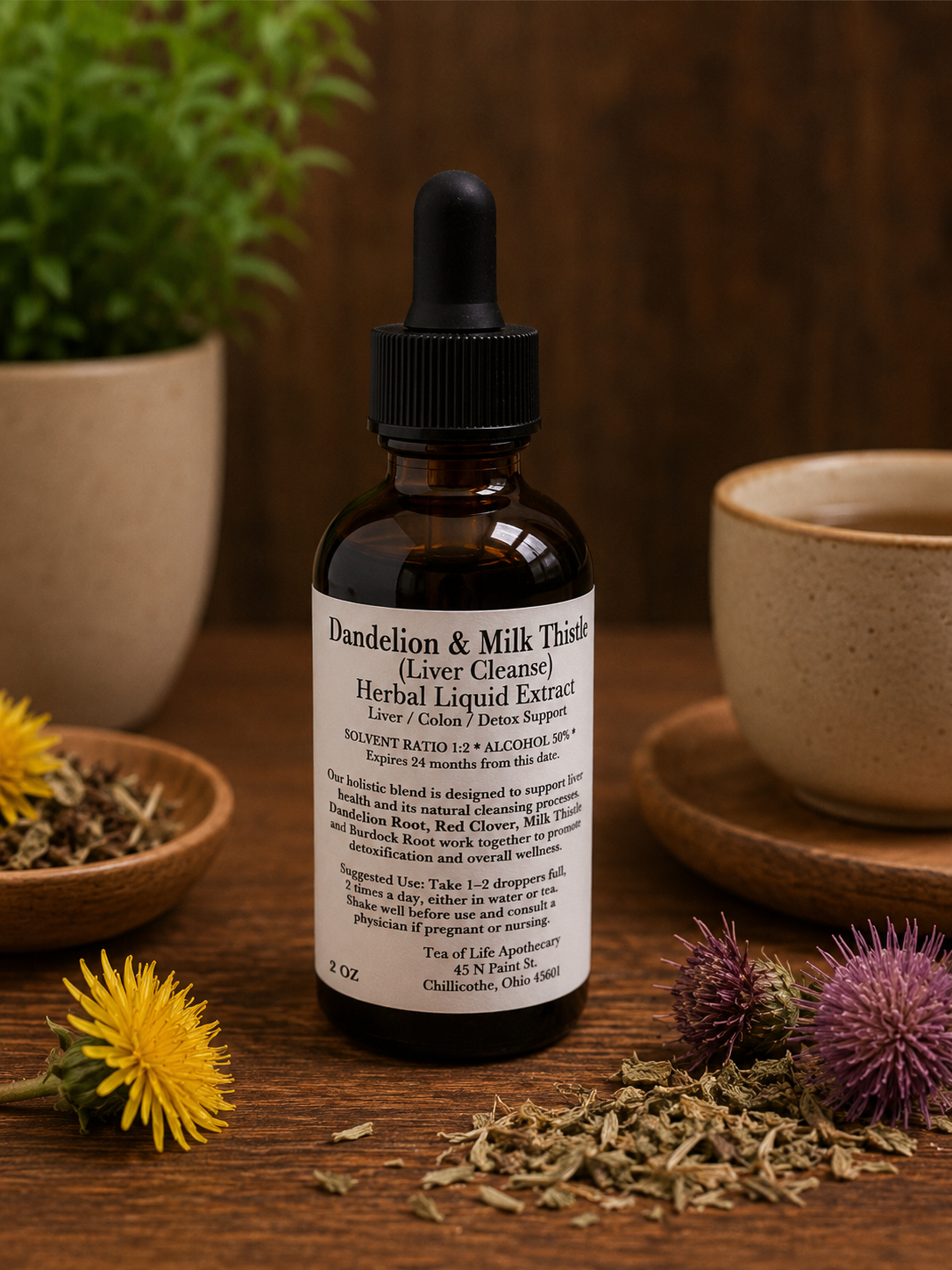 Tea of Life Apothecary Dandelion and Milk Thistle Liver Cleanse herbal liquid extract tincture bottle displayed on a rustic wooden table with dandelion flowers, milk thistle, and dried herbs in a warm apothecary setting.