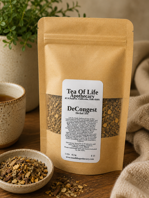 DeCongest Herbal Tea by Tea of Life Apothecary displayed in a cozy rustic setting with loose herbal ingredients, ceramic tea cup, and warm natural lighting to highlight respiratory, sinus, and congestion support.