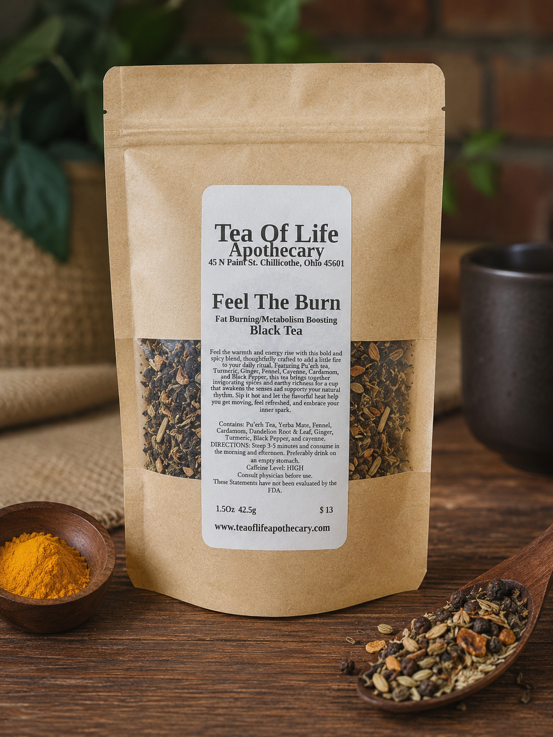 Feel The Burn fat burning and metabolism boosting black tea by Tea of Life Apothecary in a rustic product display with pu'erh tea, turmeric, ginger, fennel, cayenne, cardamom, and black pepper on a wooden table.