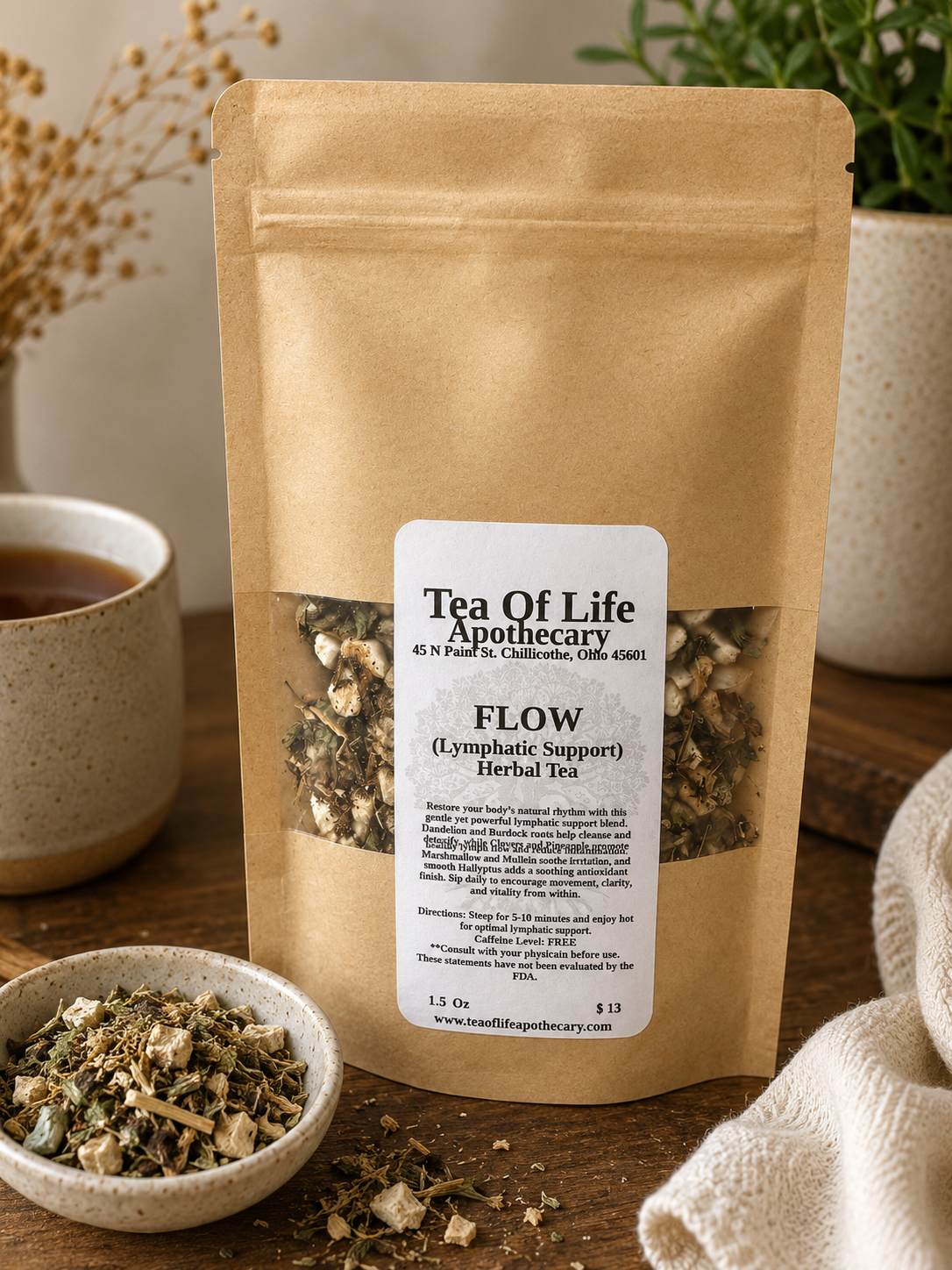 FLOW Lymphatic Support Herbal Tea by Tea of Life Apothecary displayed in a warm rustic apothecary setting with loose herbs, a ceramic tea cup, and natural lighting to highlight herbal lymphatic and detox support.