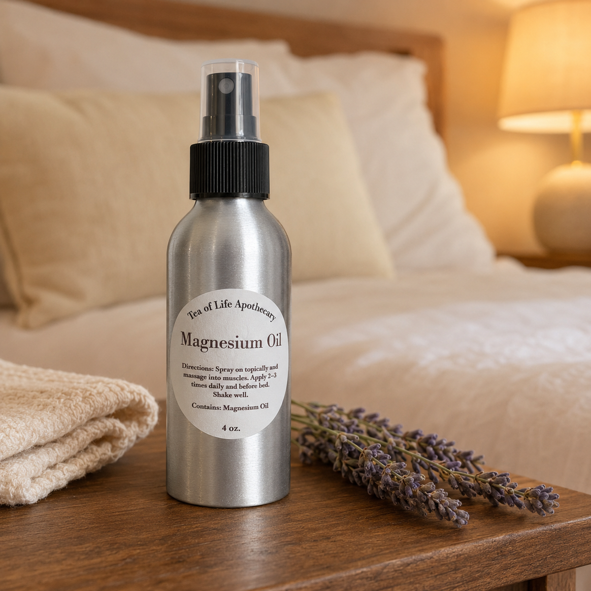 Tea of Life Apothecary Magnesium Oil spray bottle displayed on a wooden nightstand beside a cozy bed with lavender.