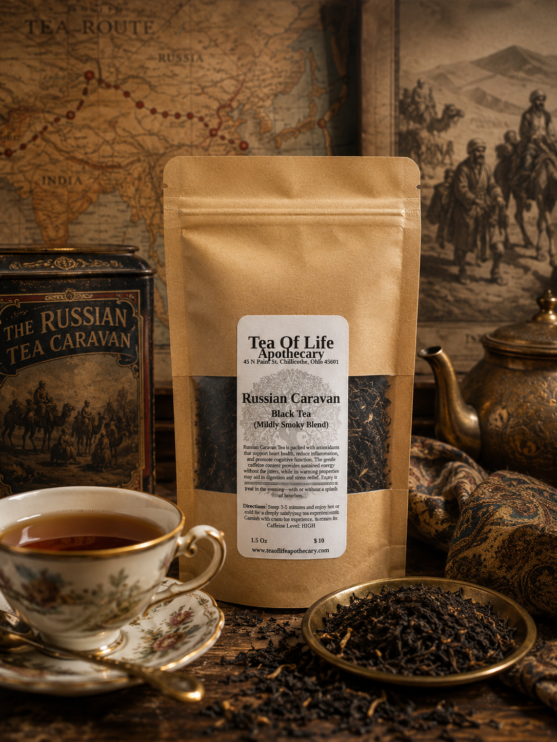 A stand-up pouch of Tea Of Life Apothecary Russian Caravan Black Tea stands on a rustic wooden surface, surrounded by a teacup, saucer, loose tea in a dish, and vintage-style tea caravan packaging and artwork.