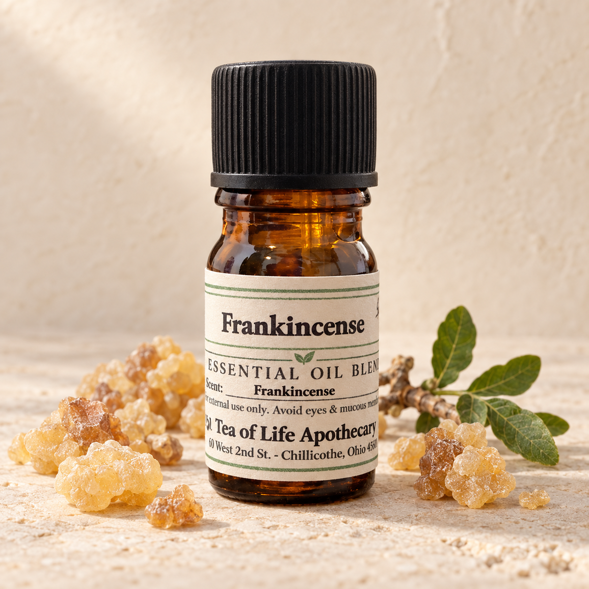 Tea of Life Apothecary Frankincense Essential Oil in a 5 mL amber glass bottle, displayed with natural frankincense resin and botanical leaves.