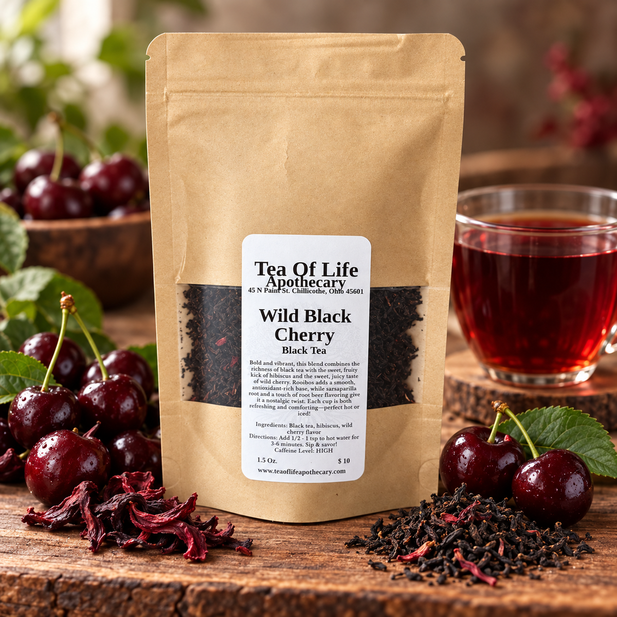 Tea of Life Apothecary Wild Black Cherry Black Tea displayed with ripe dark cherries, hibiscus petals, loose-leaf tea, and a vibrant ruby-red cup of brewed tea.