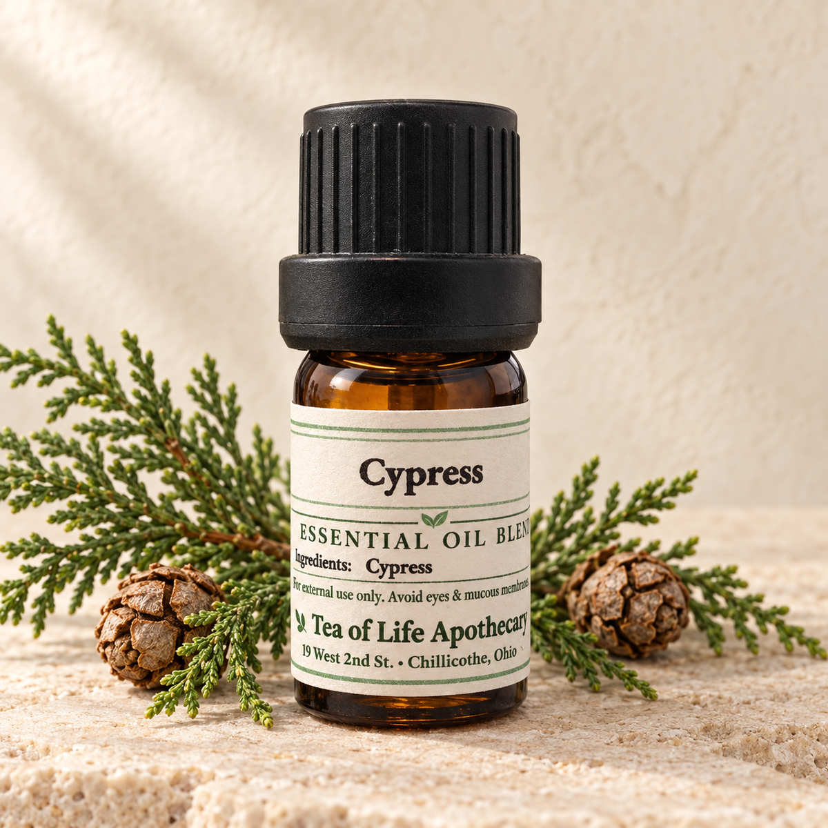 Tea of Life Apothecary Cypress Essential Oil in a 5 mL amber glass bottle, displayed with natural cypress foliage and cones.