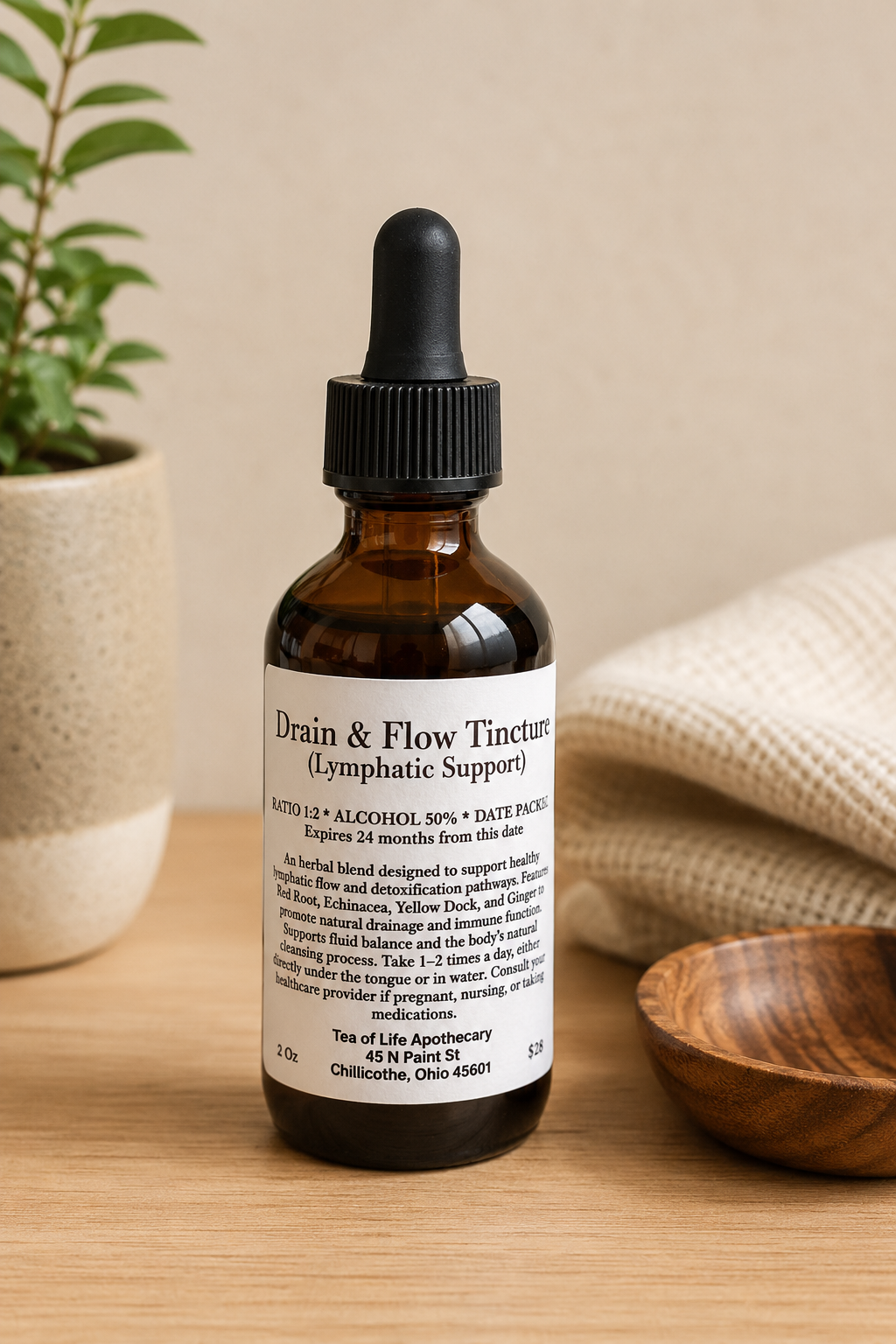 Amber glass dropper bottle of Drain & Flow Lymphatic Support herbal tincture by Tea of Life Apothecary displayed on a wooden surface with soft natural lighting and neutral apothecary-style decor.