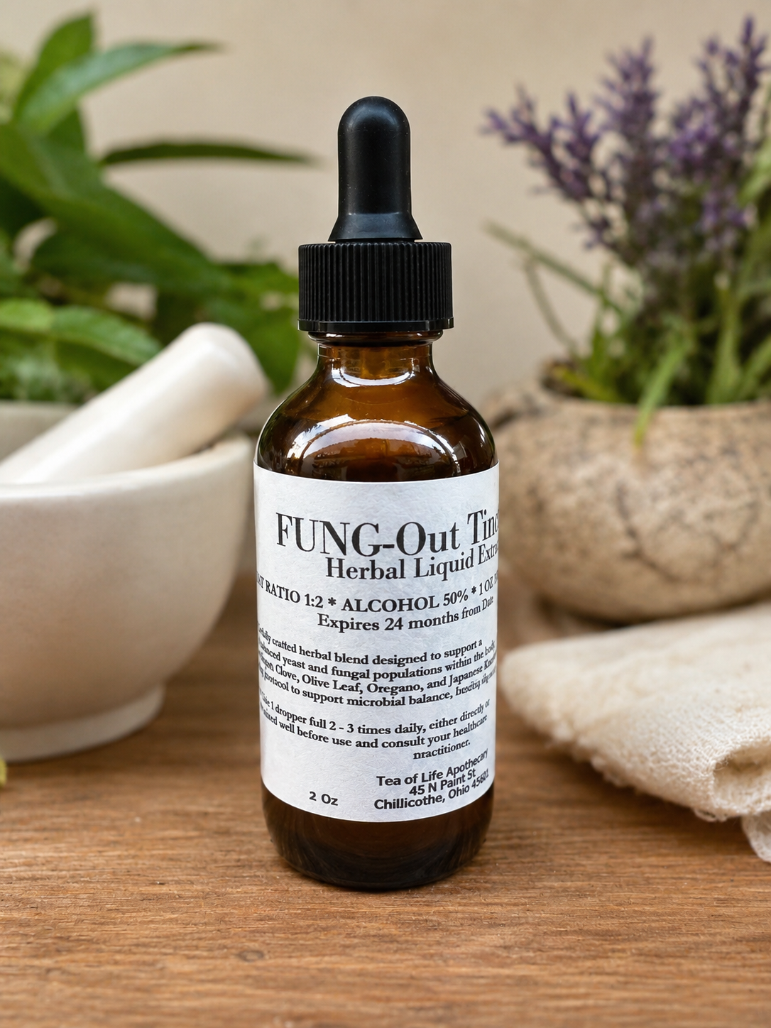 Professional product photo of Tea of Life Apothecary's FUNG-Out Herbal Tincture in an amber glass dropper bottle, formulated with herbs traditionally used to support microbial balance and healthy yeast and fungal flora. Handcrafted in Chillicothe, Ohio.