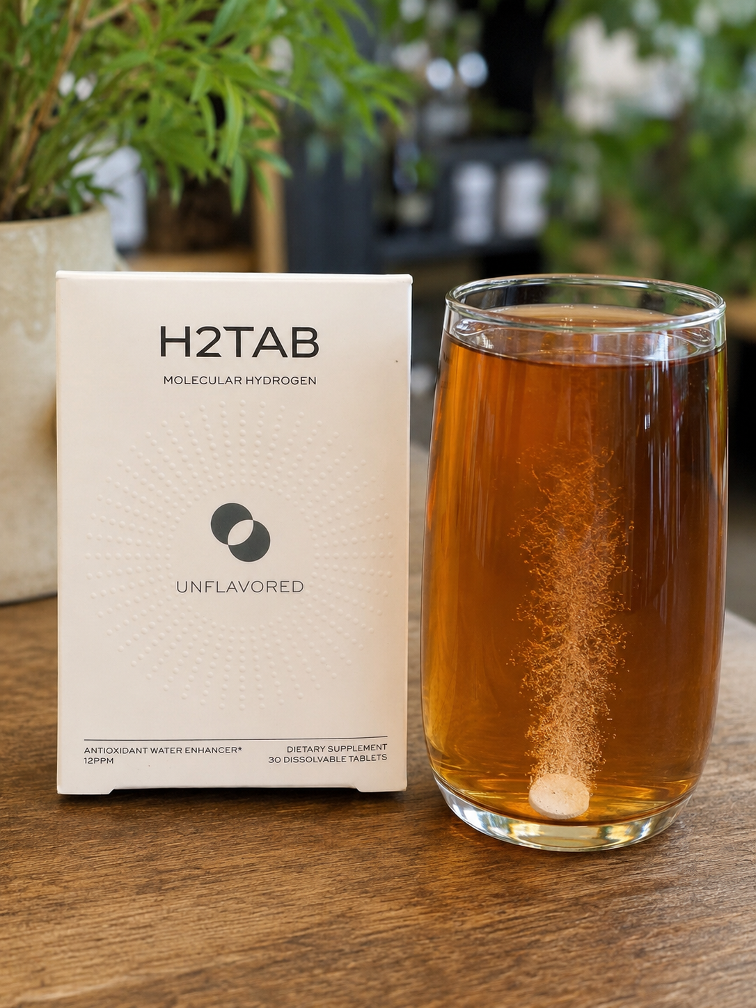 H2Tab Molecular Hydrogen Tablets beside a glass of iced herbal tea with a dissolving hydrogen tablet fizzing at the bottom. Molecular hydrogen can be added to cooled or iced tea to support antioxidant activity, cellular wellness, mitochondrial health, and a healthy inflammatory response.