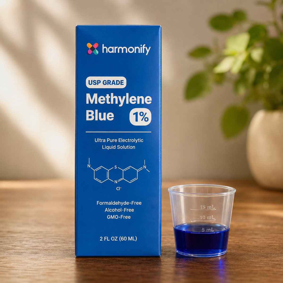 Harmonify USP Grade Methylene Blue 1% solution displayed beside a clear medicine cup containing approximately 5 mL of deep-blue liquid.
