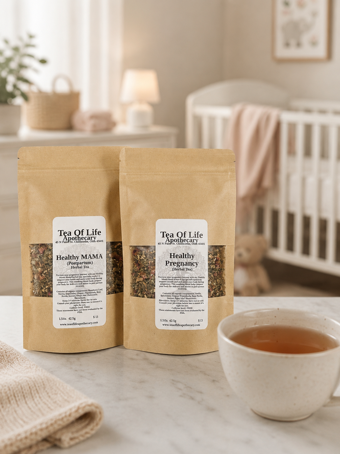 Tea of Life Apothecary Healthy Pregnancy and Healthy MAMA herbal tea blends displayed on a countertop beside a warm cup of tea, with a softly blurred baby nursery featuring a crib and nursery décor in the background.
