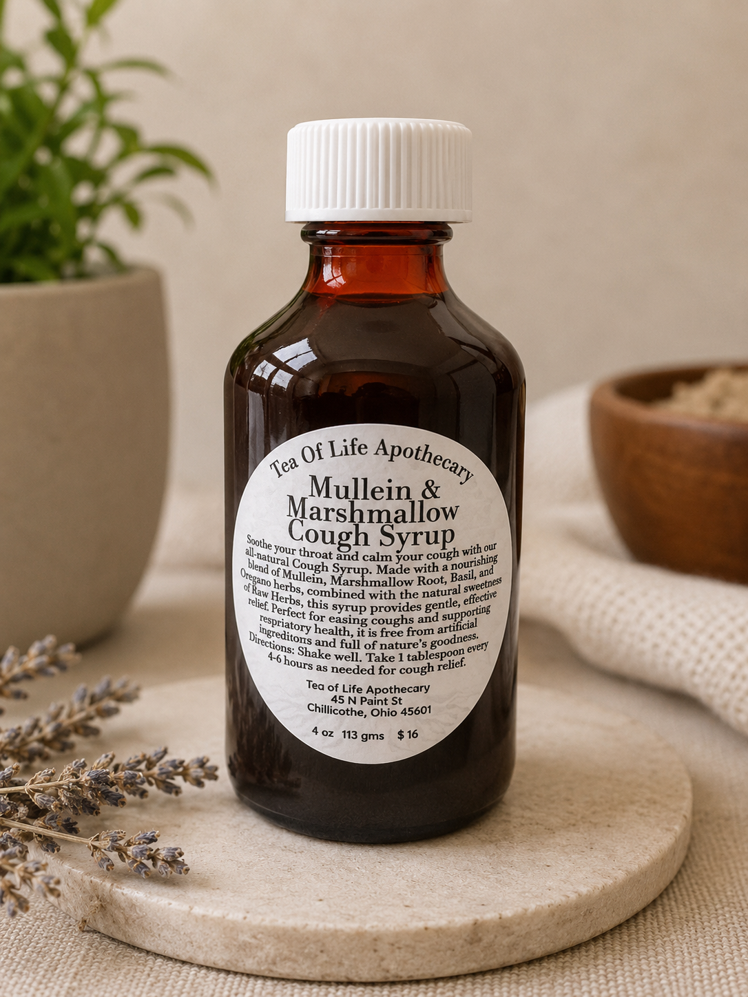Amber glass bottle of Mullein and Marshmallow herbal cough syrup from Tea of Life Apothecary displayed in a calming natural wellness setting with soft lighting and botanical accents.