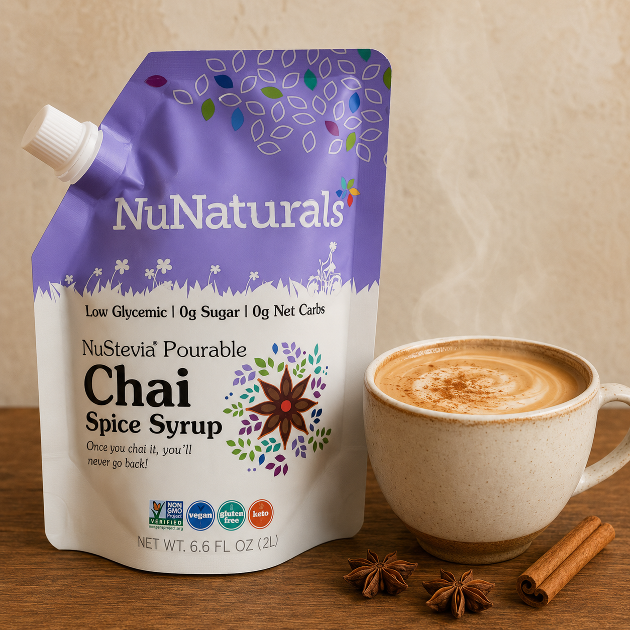 NuNaturals sugar-free Chai Spice Syrup beside a steaming cup of creamy chai tea with cinnamon and star anise.