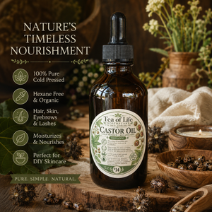 Tea of Life Apothecary organic castor oil in an amber glass dropper bottle, cold pressed and hexane free, displayed in a rustic botanical setting with castor beans and herbs.