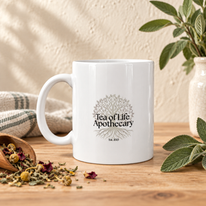 White ceramic mug featuring the Tea of Life Apothecary tree logo and Est. 2023 design.