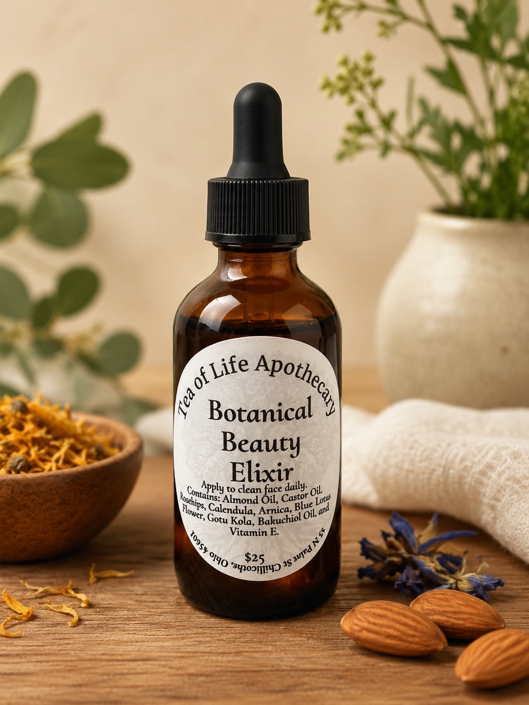 Tea of Life Apothecary Botanical Beauty Elixir facial oil in an amber glass dropper bottle displayed on a rustic wooden surface with almonds, calendula petals, and blue lotus flowers. Features nourishing botanical ingredients including sweet almond oil, castor oil, rosehips, calendula, arnica, gotu kola, bakuchiol oil, and vitamin E for natural skincare support.