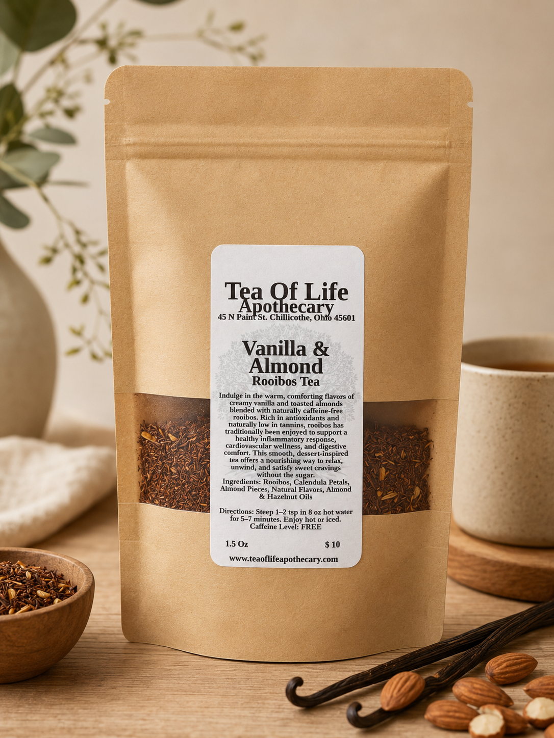 Tea of Life Apothecary Vanilla & Almond Rooibos Tea in a kraft stand-up pouch displayed on a rustic wooden surface with vanilla beans, almonds, and a warm cup of tea, showcasing a naturally caffeine-free herbal rooibos blend.